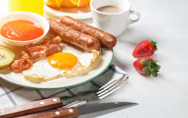 Voedzaam ontbijt, aardbei, brood, koffie sinaasappelsap, worst, ei