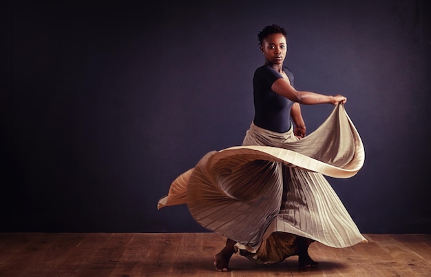 Voel de beweging van een hedendaagse danseres in een dramatische pose tegen een donkere achtergrond