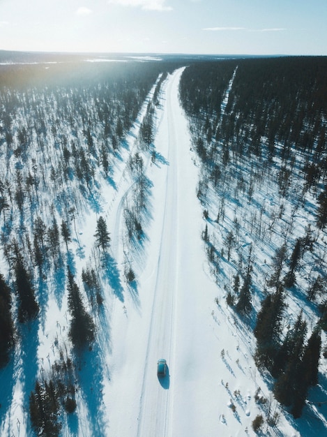 Voertuig op een besneeuwde weg tussen de bossen