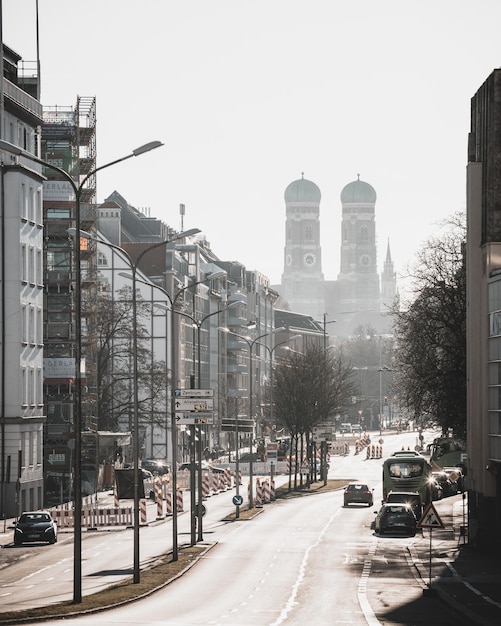 Voertuigen op de weg bij gebouwen tegen een heldere lucht in de stad