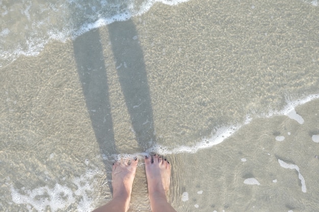 Foto voet op het zandstrand. het concept van ontspanning.