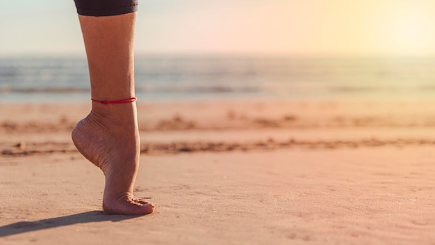 Voet op zijn tenen in balans op strandzand met zonnestralen