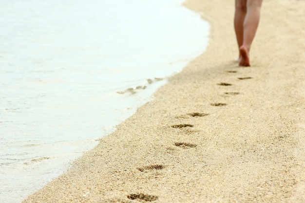 Voetafdrukken in het zand op het strand in de zomer