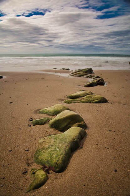 Foto voetafdrukken op het zand op het strand tegen de lucht