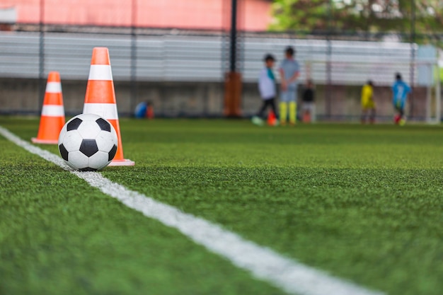 Voetbal bal tactiek kegel op grasveld met voor opleiding achtergrond Kinderen trainen in voetbal