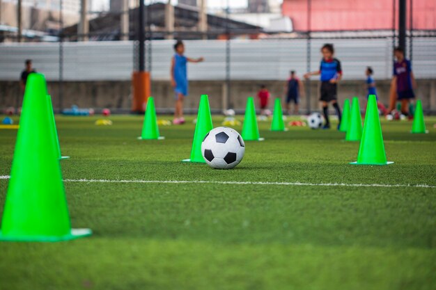 Voetbal bal tactiek kegel op grasveld met voor opleiding achtergrond Kinderen trainen in voetbal