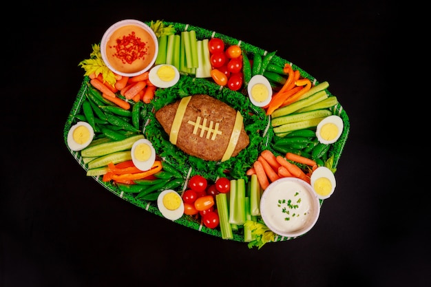 Voetbal gehaktbrood met groente, ei en saus voor super bowl feest