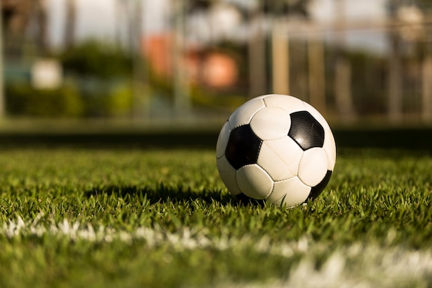 Voetbal op een grasveld, onder de zonsondergang.