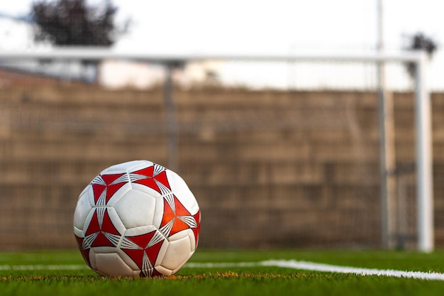 Voetbal op het gras voor het veld Uitzicht vanaf de grond van een voetbal voor het veld Uitzicht op een voetbal op het gras met een veld op de achtergrond