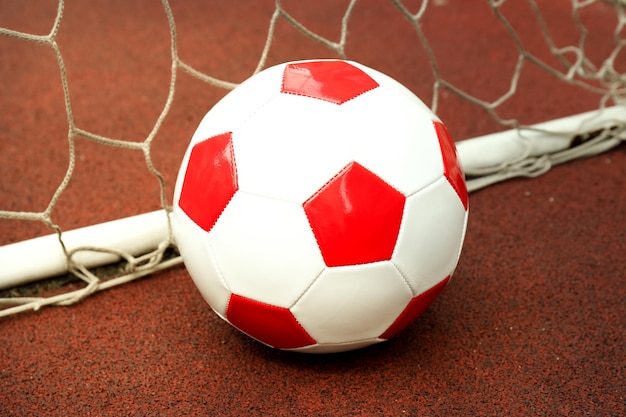 Voetbalbal en voetbaldoel op rubberen coating op de speelplaats