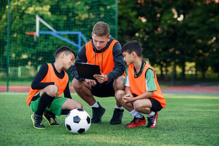 Voetbalcoach toont een strategie van voetbalwedstrijd aan zijn spelers tijdens de training.