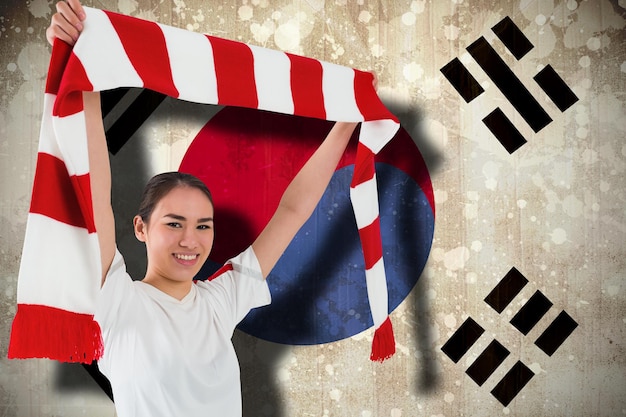 Voetbalfan zwaaiende rode en witte sjaal tegen de vlag van zuid-korea