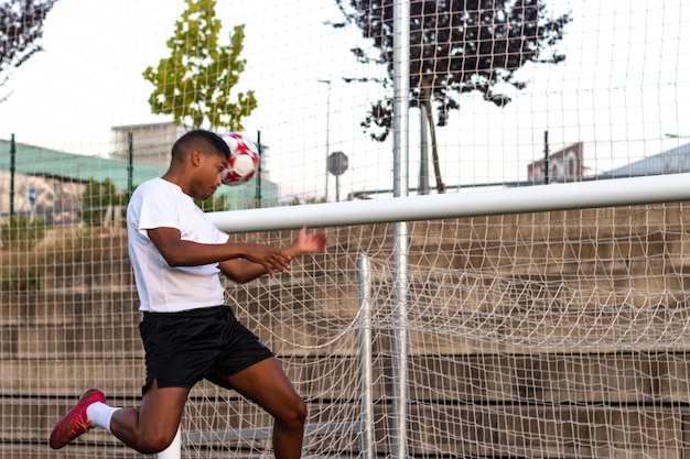 Voetballer die een kopbaldoelpunt scoort Voetbalman op het veld die een kopbaldoel scoort Concept doel met het hoofd