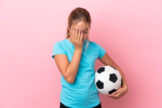 Voetballer meisje geïsoleerd op roze achtergrond met vermoeide en zieke expressie