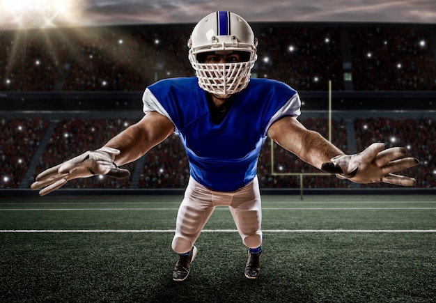 Voetballer met een blauw uniform die een uitrusting op een stadion maakt