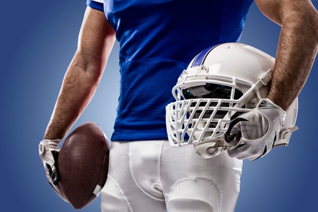 Voetballer met een blauw uniform op een blauwe muur