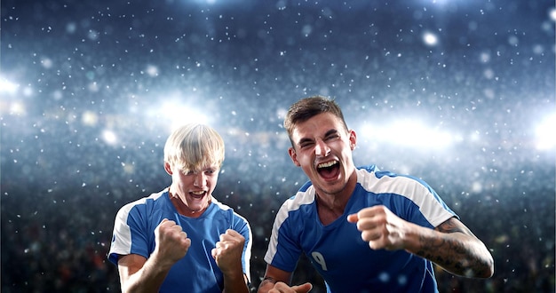 Foto voetballer viert een overwinning in het professionele stadion terwijl het sneeuwt stadion en publiek zijn gemaakt in 3d