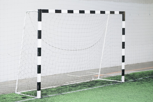 Voetbalpoorten en net tegen witte muur op groen veld in het stadion voor sporttrainingen en wedstrijden