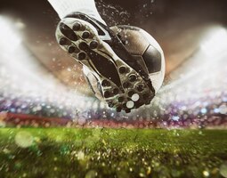 Foto voetbalscène bij nachtwedstrijd met close-up van een voetbalschoen die de bal met kracht raakt