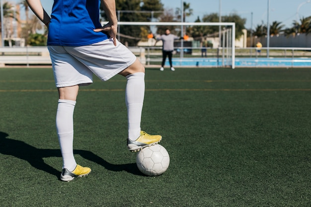 Foto voetbalster die met bal naar doel kijkt