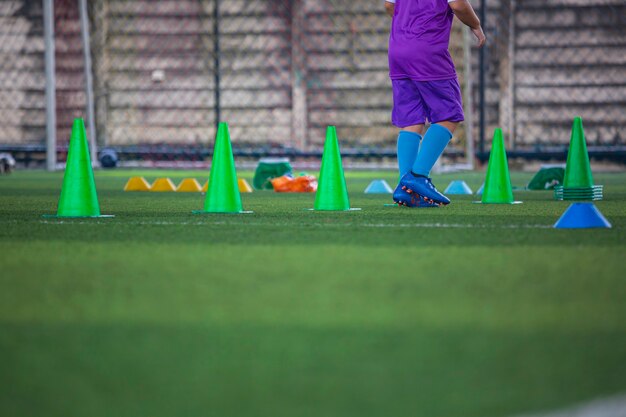 Voetbaltactieken op grasveld met kegel voor training op de achtergrond Kinderen trainen in de voetbalacademie