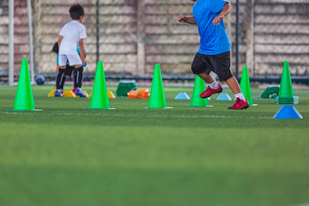 Voetbaltactieken op grasveld met kegel voor training op de achtergrond Kinderen trainen in de voetbalacademie