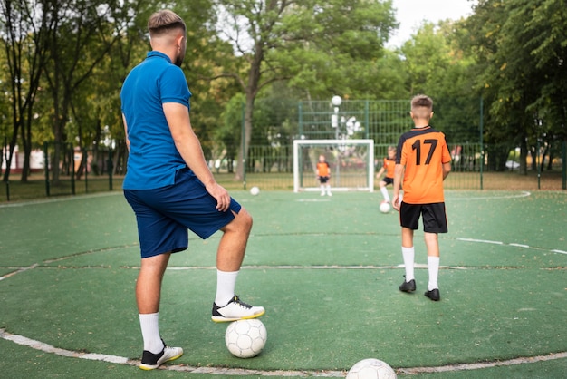 Foto voetbaltrainer die zijn leerlingen lesgeeft