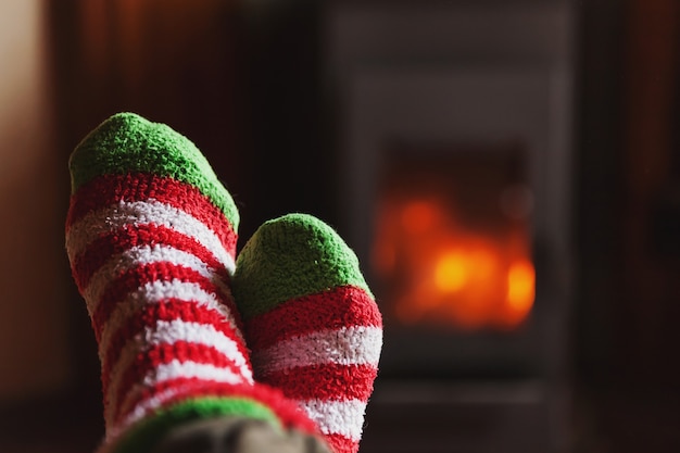 Voeten benen in winterkleren wollen sokken bij open haard