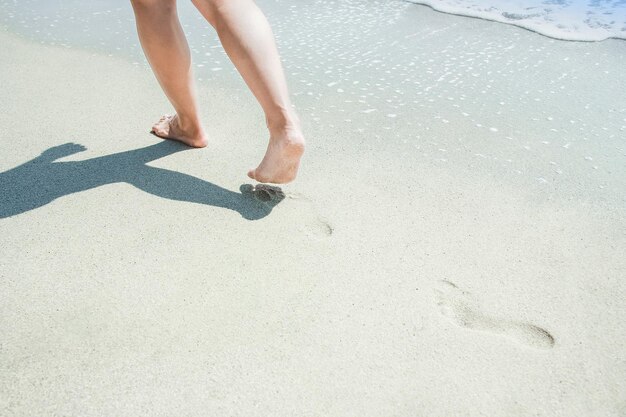 Voeten en voetafdrukken aan de kust op de achtergrond van de vakantie in de natuur