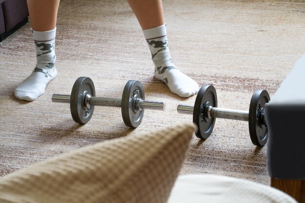 Voeten met sokken. Train op de thuismat met fitnessaccessoires zoals dumbbells