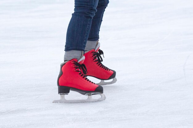 Voeten op de schaatsen van een persoon die op de ijsbaan rolt. Hobby's en sporten. Vakanties en winteractiviteiten.