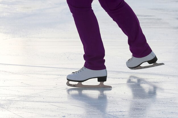 Voeten op de schaatsen van een persoon die op de ijsbaan rolt. Sport- en wintervakanties