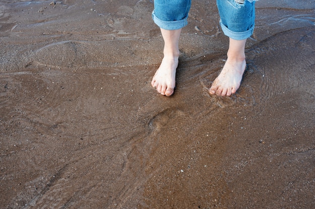 Voeten op het strand in zonnige zomerdag