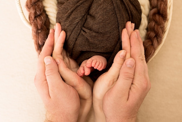 voeten van de pasgeboren baby met moeder en vader handen, vingers op de voet, ouders zorg, liefde en familie knuffels concept, tederheid. Kopieer ruimte.