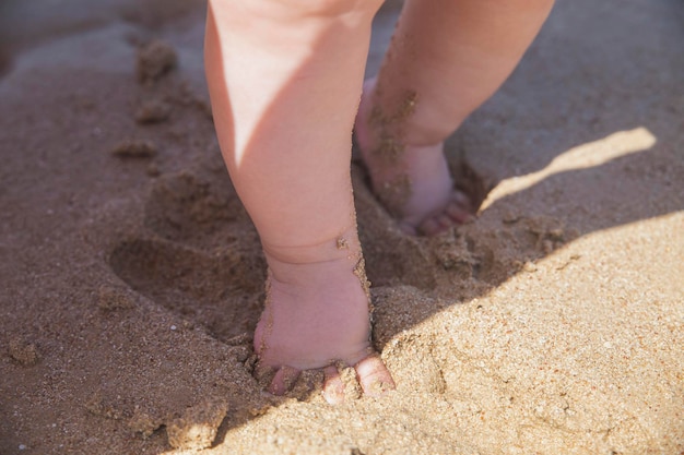 Voeten van een baby die langs de kust loopt