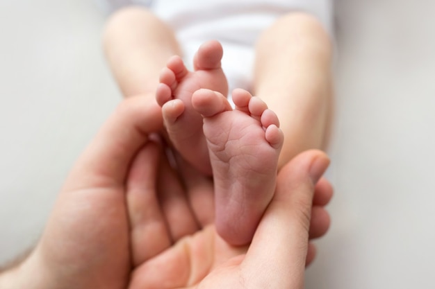 Voeten van een pasgeborene in de handen van een vader, ouder. studiofotografie, witte achtergrond. gelukkig familieconcept. hoge kwaliteit foto