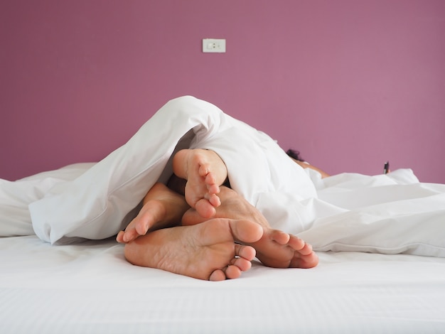 voeten van het paar liefhebbers hebben seks op een bed in de ochtend met lust en liefde