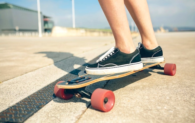 Voeten van jonge vrouw op longboard, close-up