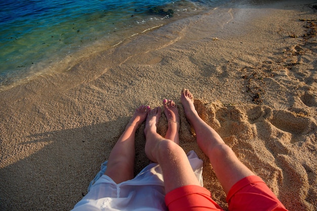 Voeten van man en vrouw op het gele zand