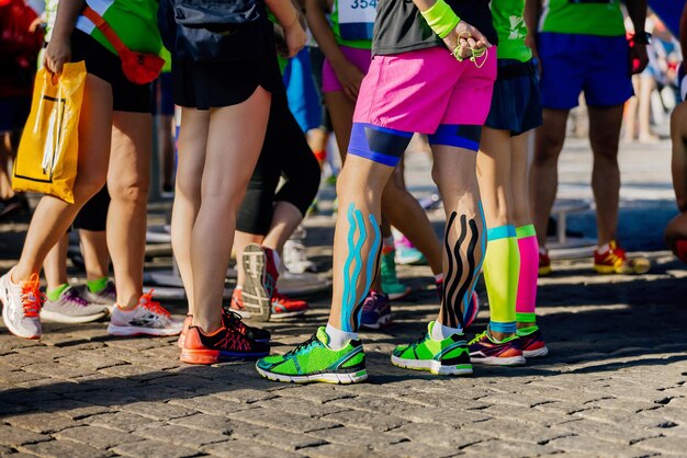 Foto voeten vrouwelijke hardlopers met kinesio tape en compressie sokken