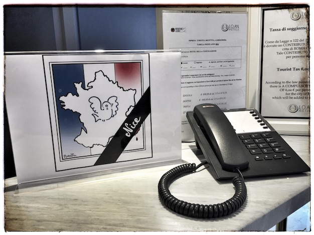 Vogels tekenen op de Franse vlag via een vaste telefoon op het bureau in het kantoor