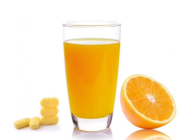 Vol glas sinaasappelsap en vitamine C pillen geïsoleerd op wit