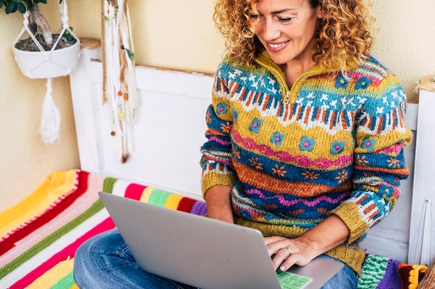 vol kleurenafbeelding voor vrouw van middelbare leeftijd die vrijheid op laptop buiten op het terras werkt, planten en natuur op de achtergrond voor onafhankelijkheidsconcept