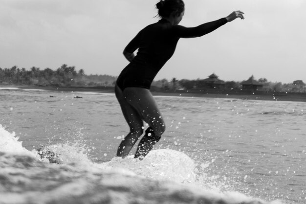 Foto vol lengte van jonge vrouw die op het water staat