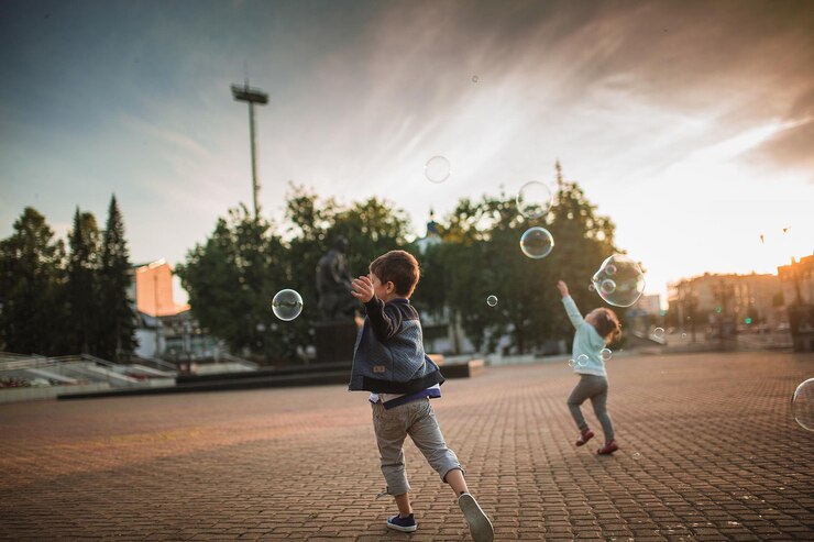 Foto vol lengte van kinderen die spelen tegen de hemel tijdens zonsondergang