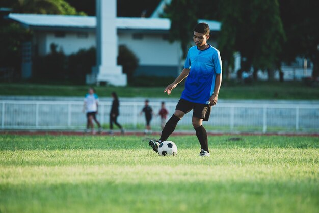 Foto vol lengte van man die voetbal speelt op het veld