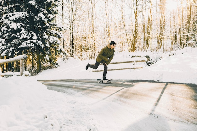 Vol lengte van man skateboarden in de sneeuw