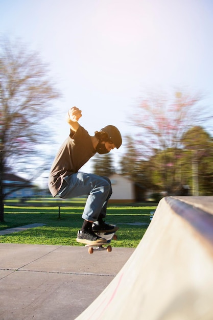 Vol lengte van man skateboarden op skateboard tegen de lucht