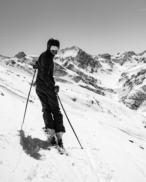Vol lengte van man skiën op besneeuwde berg tegen de lucht