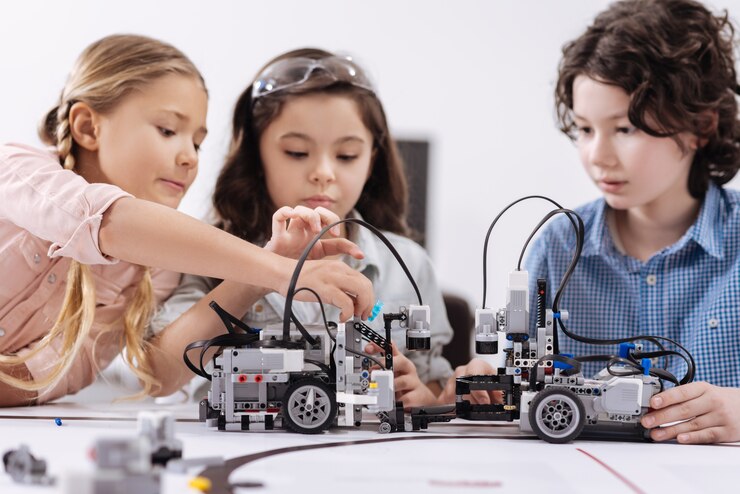 Vol met creatieve ideeën. Hoogbegaafde geconcentreerde positieve kinderen zitten in de klas en bouwen een robot terwijl ze aan het project werken